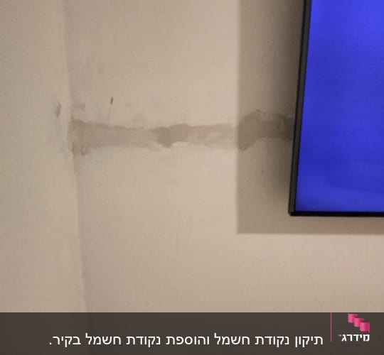 קיר עם סימני תיקון ליד מסך טלוויזיה